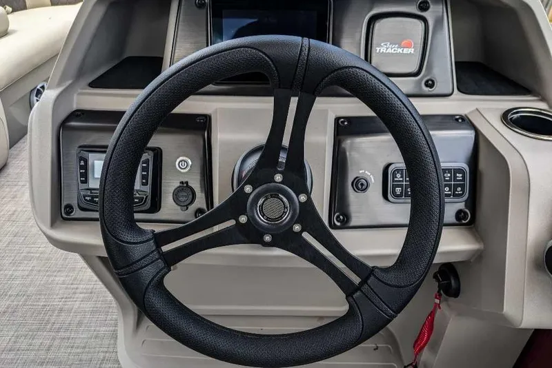 Slide: The Image of 2024 Sun Tracker Party Barge 20 DLX steering wheel and dashboard controls. - 8