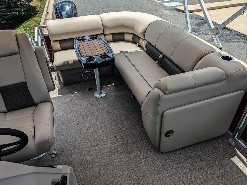 Slide: The Image of 2024 Sun Tracker Party Barge 20 DLX interior with plush seating and table. - 9