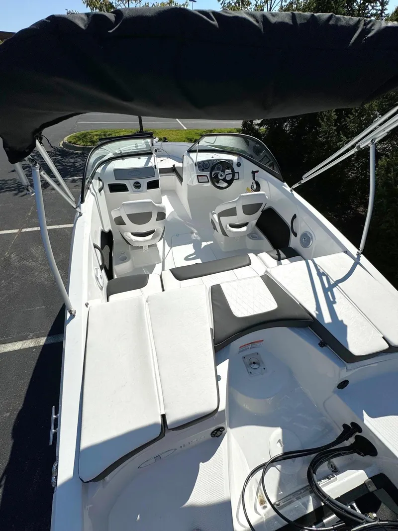 Slide: The Image of 2024 Tahoe 185 S boat interior with seating and steering wheel, under a canopy. - 3