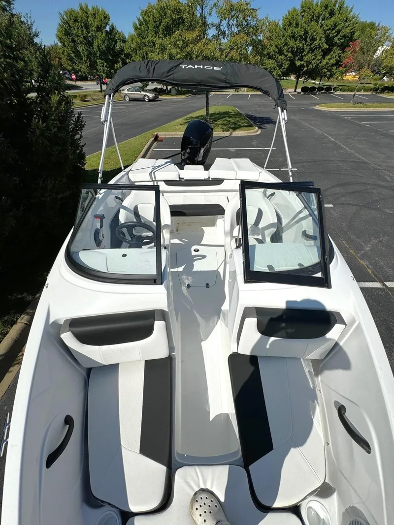 Slide: The Image of 2024 Tahoe 185 S boat with open deck and seating, parked outdoors. - 4