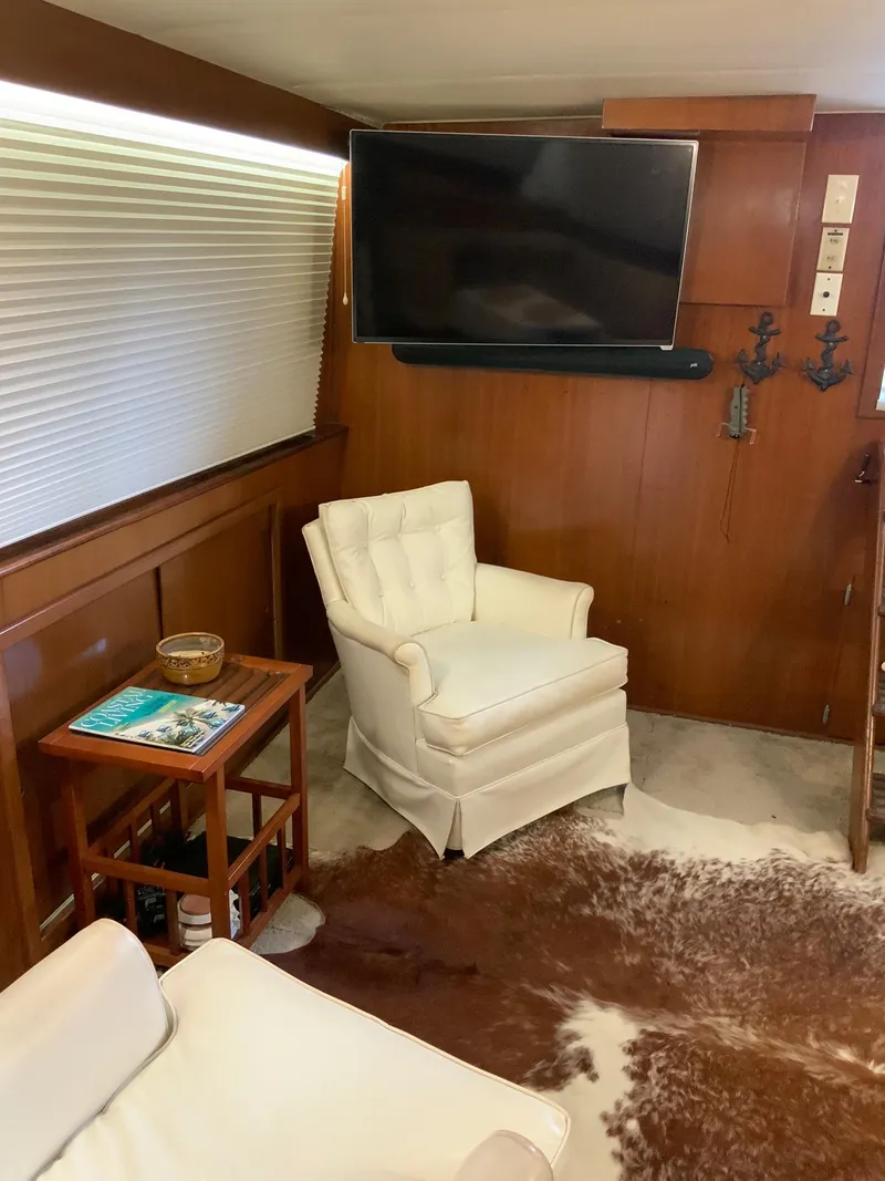 Slide: The Image of Interior of 1969 Hatteras 41 Double Cabin with white armchair and wall-mounted TV. - 33