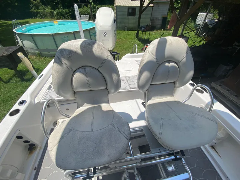 Slide: The Image of 2019 Blue Wave 2400 PureBay boat with dual captain's chairs in backyard setting. - 31