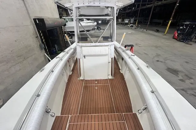 Slide: The Image of 1976 SeaCraft 23 Classic boat with wooden deck, docked in a warehouse setting. - 4