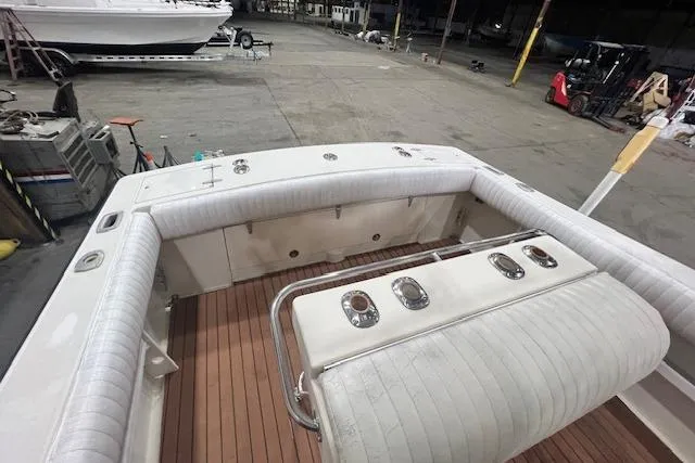 Slide: The Image of 1976 SeaCraft 23 Classic boat interior with cushioned seating and wooden deck in a warehouse. - 5