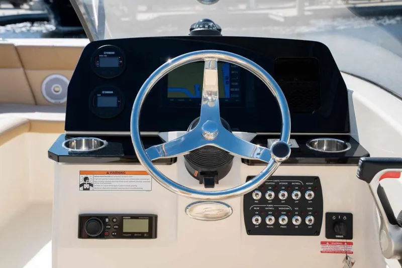 Slide: The Image of 2025 Scout 215 Dorado boat dashboard with steering wheel and control panel. - 1