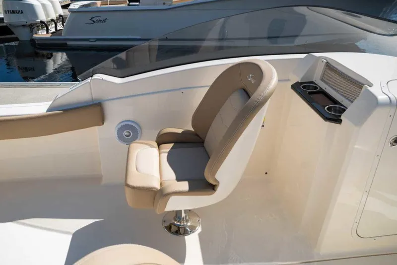 Slide: The Image of 2025 Scout 215 Dorado boat interior with beige captain's chair and cup holders. - 12