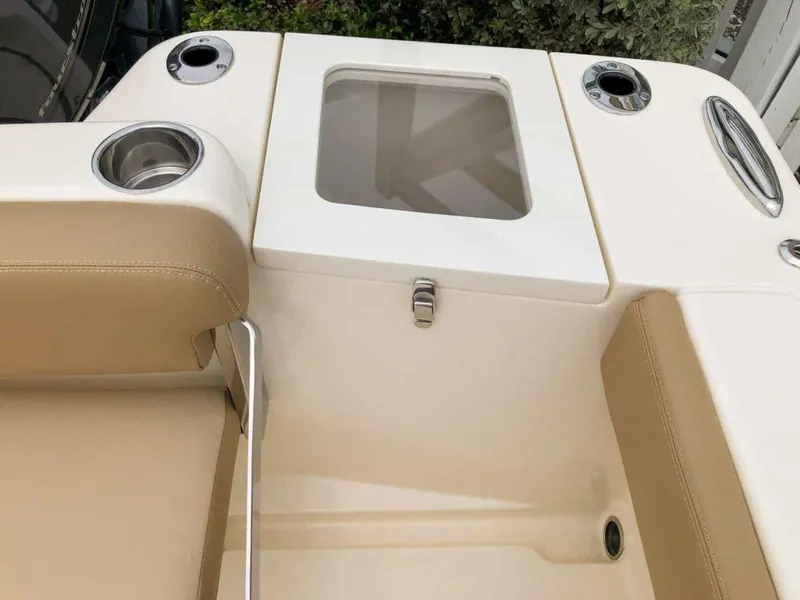 Slide: The Image of 2025 Scout 215 Dorado boat interior with beige seating and storage compartment. - 6