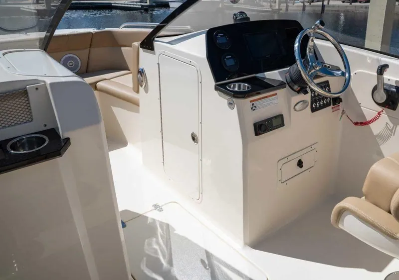 Slide: The Image of 2025 Scout 215 Dorado boat interior with steering console and seating. - 9