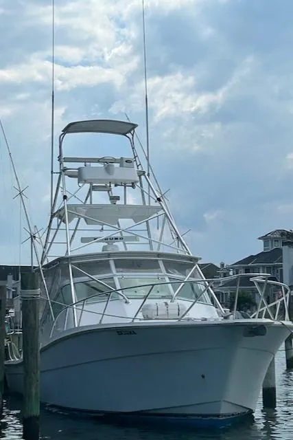 Slide: The Image of 2006 Topaz 40 Express boat docked at a marina under a cloudy sky. - 26