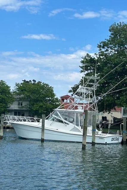 Slide: The Image of 2006 Topaz 40 Express boat docked in a serene marina. - 29