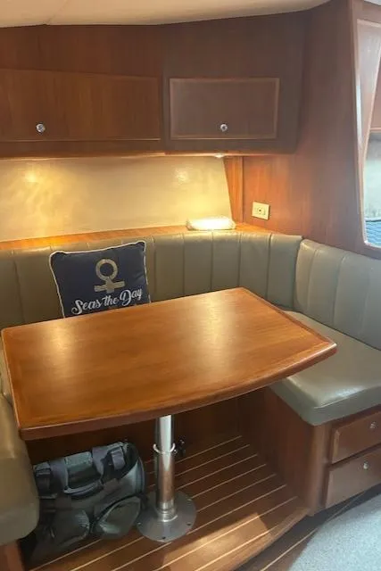 Slide: The Image of Cozy dining area in 2006 Topaz 40 Express yacht with wooden table and cushioned seating. - 4