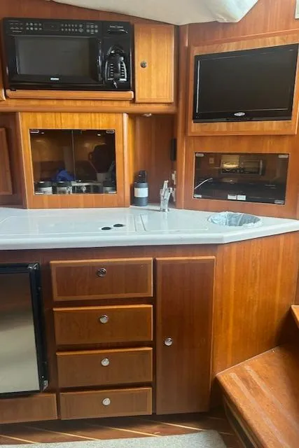 Slide: The Image of 2006 Topaz 40 Express yacht interior with kitchen appliances and wooden cabinetry. - 8