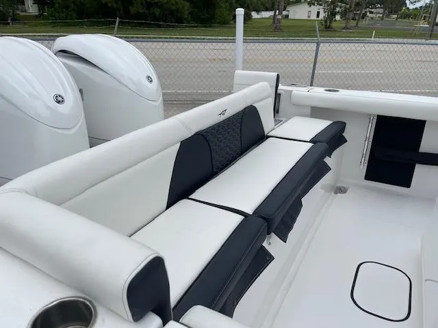 Slide: The Image of 2025 Tidewater 256 LXF boat interior with cushioned seating and dual outboard motors. - 22