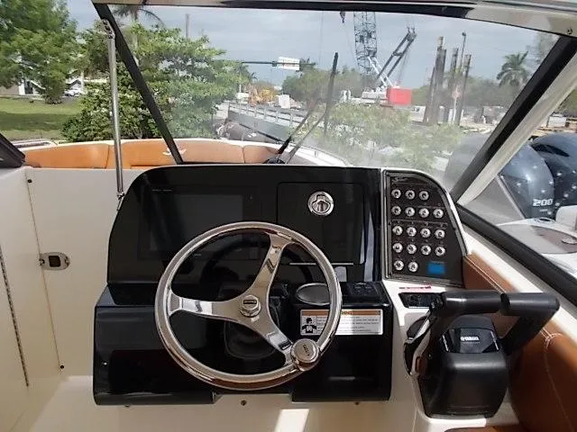 Slide: The Image of 2025 Scout 255 Dorado boat dashboard with steering wheel and control panel. - 14