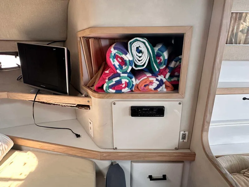 Slide: The Image of Interior of 1992 Four Winns 365 Express with colorful towels and a small TV. - 21