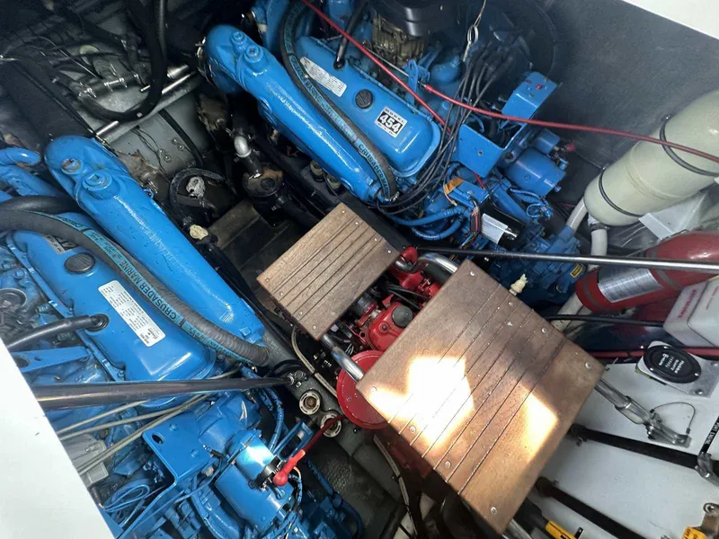 Slide: The Image of Engine room of 1992 Four Winns 365 Express with blue engines and wooden panels. - 26