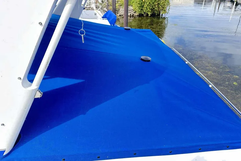 Slide: The Image of Blue canvas cover on 1992 Four Winns 365 Express boat, docked by the water. - 3