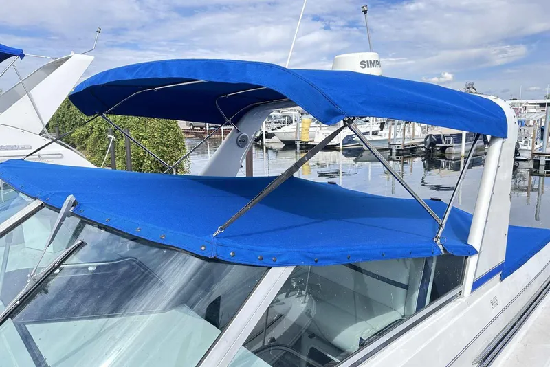 Slide: The Image of 1992 Four Winns 365 Express boat with blue canopy at marina. - 4