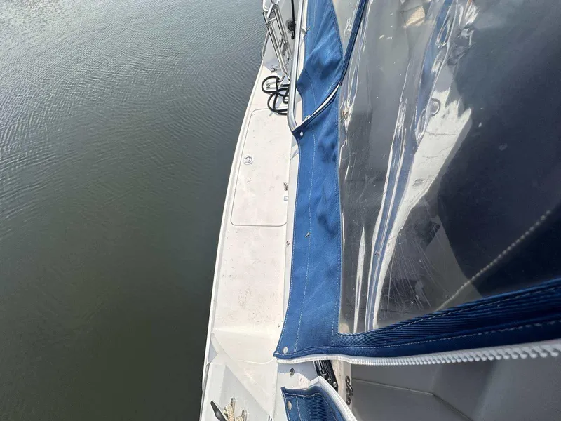 Slide: The Image of 1992 Four Winns 365 Express boat with blue canopy on calm water. - 5