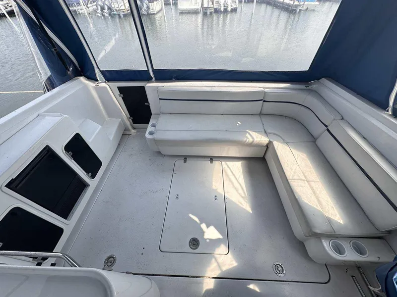 Slide: The Image of 1992 Four Winns 365 Express boat interior with spacious seating and marina view. - 6