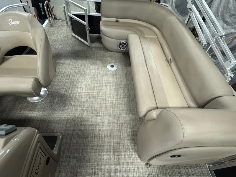 Slide: The Image of 2024 Ranger Reata 200C boat interior with beige seating and carpet flooring. - 10