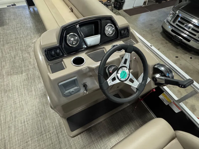 Slide: The Image of 2024 Ranger Reata 200C boat dashboard with steering wheel and controls in a showroom. - 11