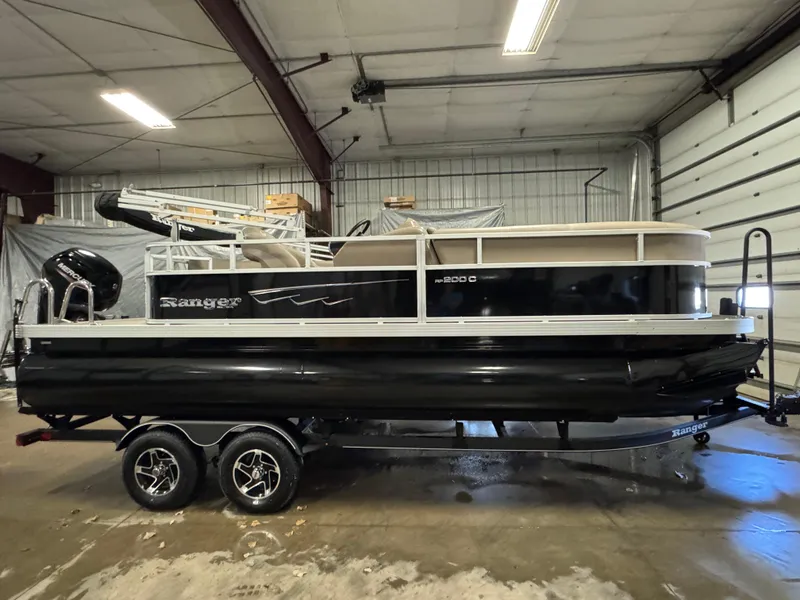 Slide: The Image of 2024 Ranger Reata 200C pontoon boat in a garage setting. - 3