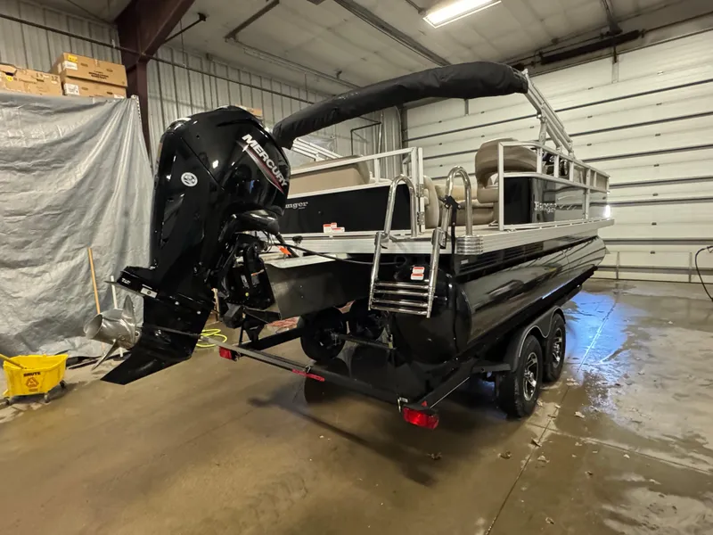 Slide: The Image of 2024 Ranger Reata 200C pontoon boat in a garage, featuring a Mercury outboard motor. - 4