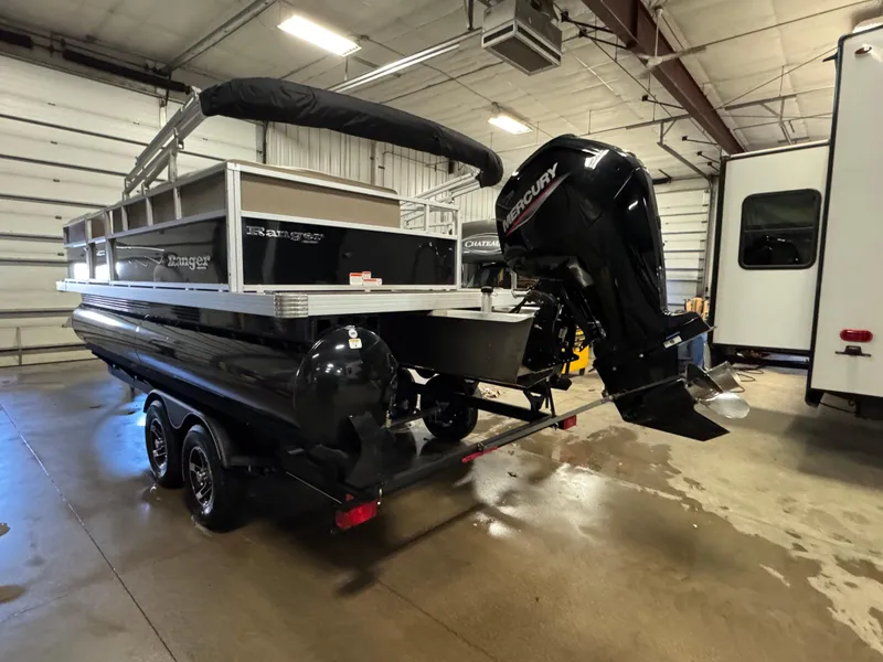 Slide: The Image of 2024 Ranger Reata 200C pontoon boat with Mercury outboard in a garage setting. - 5