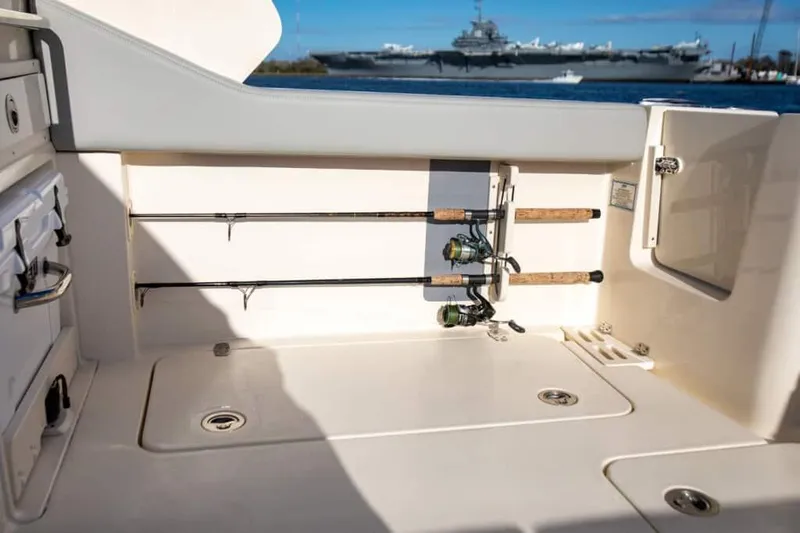 Slide: The Image of 2025 Scout 277 Dorado fishing rod storage on deck with ocean and ship in background. - 10