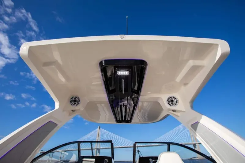 Slide: The Image of 2025 Scout 277 Dorado boat with modern canopy and speakers against blue sky. - 2