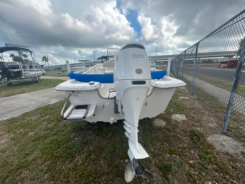 Slide: The Image of 2019 Carolina Skiff 198 DLV boat with outboard motor, parked on grass. - 3