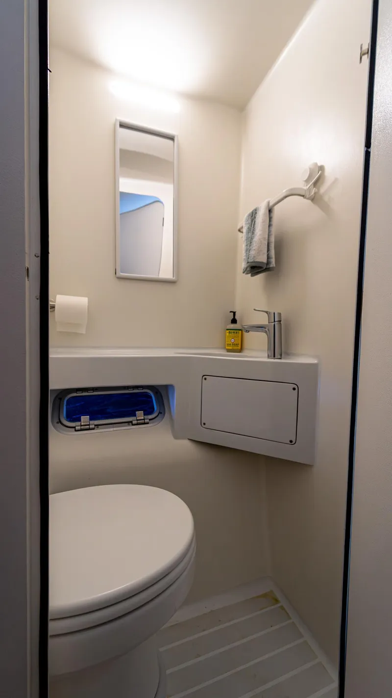 Slide: The Image of Compact bathroom in 2022 Custom Current Marine 46 boat, featuring modern fixtures and lighting. - 42