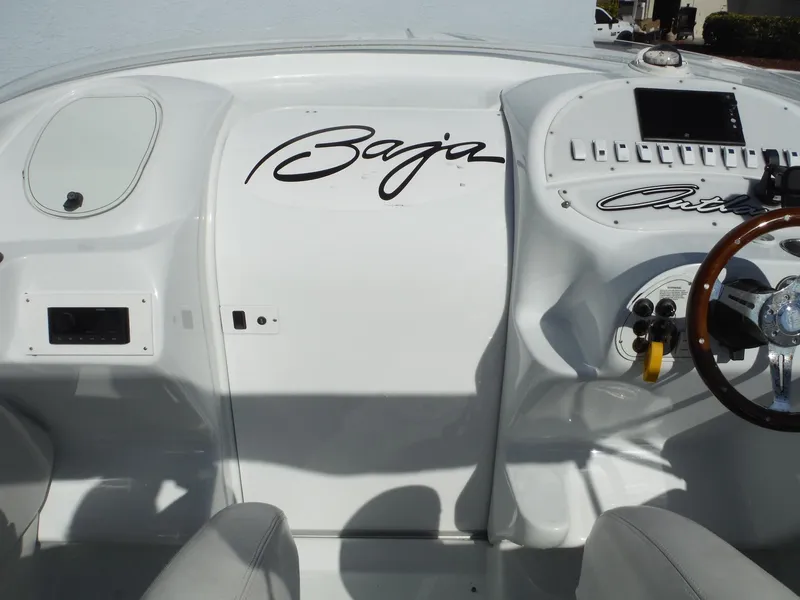 Slide: The Image of 1999 Baja 29 Outlaw boat dashboard with steering wheel and control panel. - 13