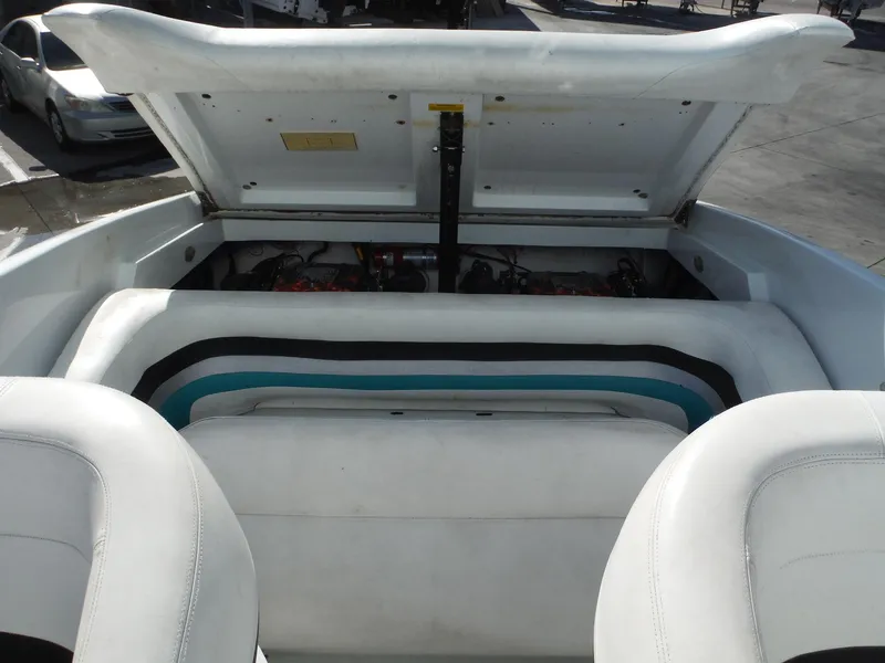 Slide: The Image of 1999 Baja 29 Outlaw boat engine compartment with open hatch, showcasing interior details. - 23