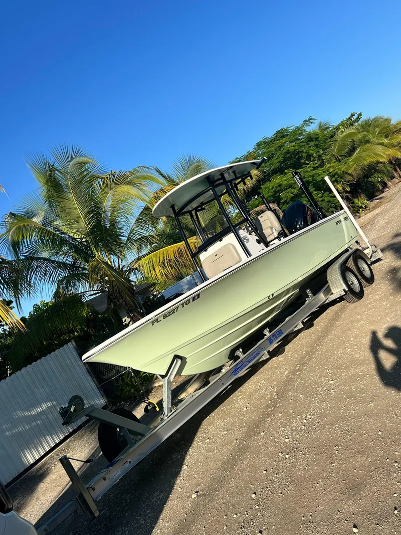 Slide: The Image of 2022 Sportsman Masters 227 Bay Boat on trailer, parked near palm trees. - 4