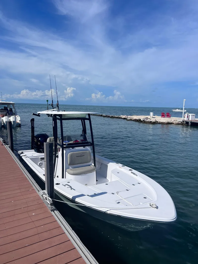 Slide: The Image of 2022 Sportsman Masters 227 Bay Boat docked by the pier on a sunny day. - 9