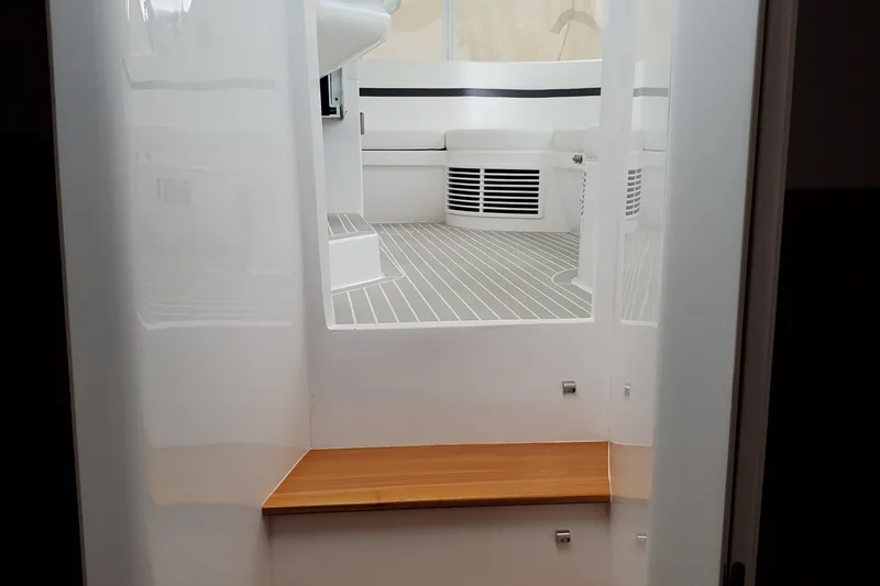 Slide: The Image of 2019 Intrepid 475 Sport Yacht interior with sleek white design and wooden accents. - 19