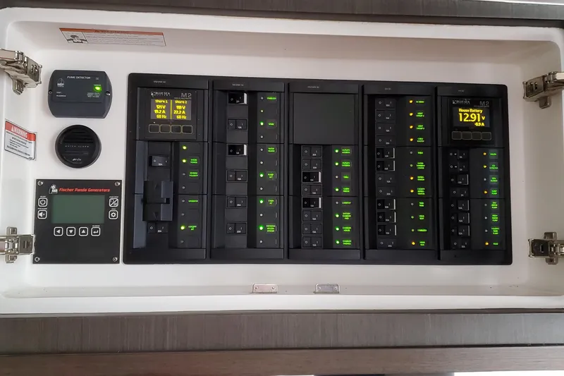 Slide: The Image of Electrical control panel of a 2019 Intrepid 475 Sport Yacht, featuring illuminated switches and displays. - 31