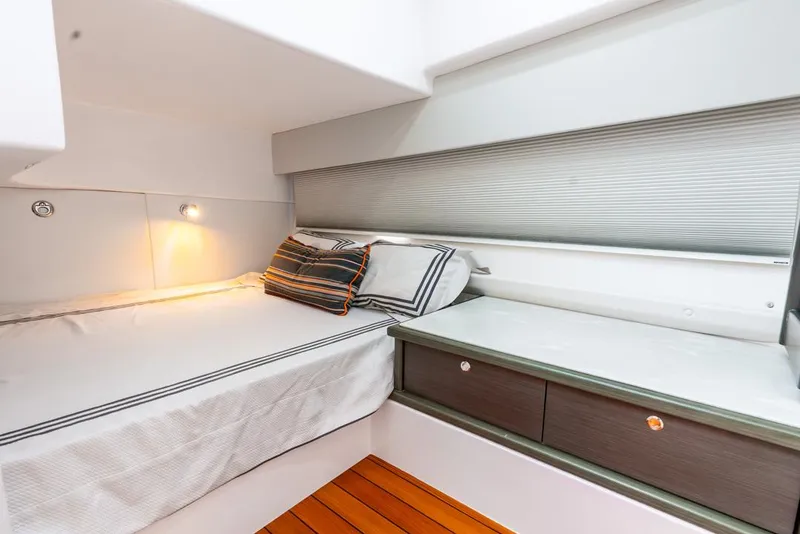 Slide: The Image of 2019 Intrepid 475 Sport Yacht cabin with bed, wooden flooring, and modern design. - 46