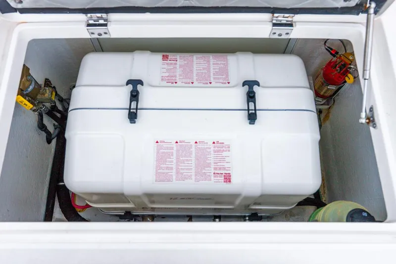 Slide: The Image of 2019 Intrepid 475 Sport Yacht storage compartment with safety equipment and fire extinguisher. - 48