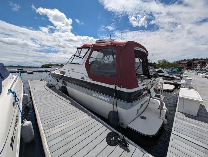 Slide: The Image of 1987 Cruisers 3370 Esprit boat docked at a marina on a sunny day. - 3