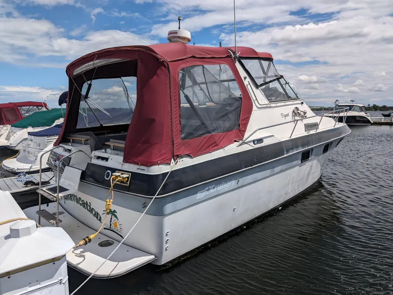 The Image of 1987 Cruisers 3370 Esprit boat docked with red canopy and clear windows. - 0