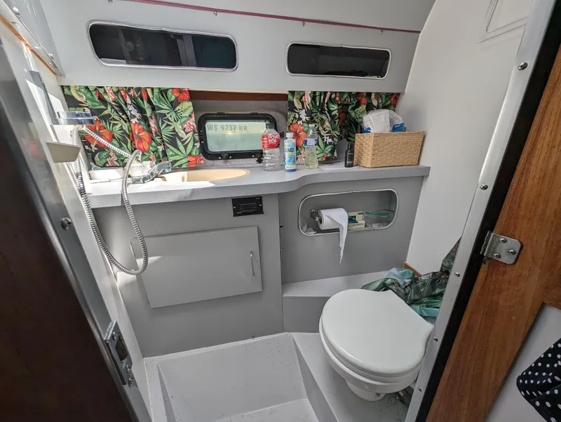 Slide: The Image of 1987 Cruisers 3370 Esprit boat bathroom with tropical curtains and modern amenities. - 18