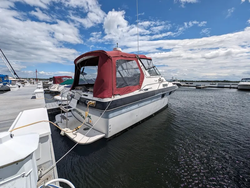 Slide: The Image of 1987 Cruisers 3370 Esprit boat docked at a marina under a partly cloudy sky. - 20