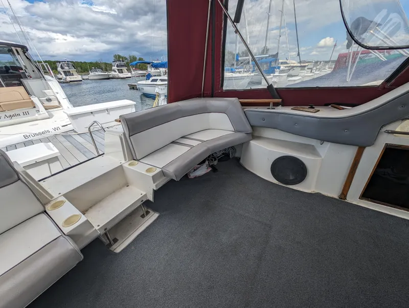 Slide: The Image of 1987 Cruisers 3370 Esprit boat interior with seating area and marina view. - 5