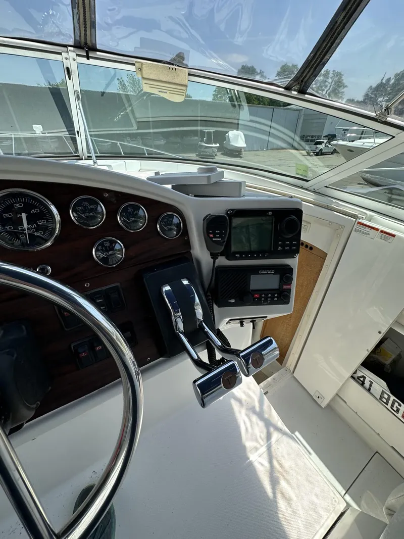 Slide: The Image of 1997 Chris-Craft 380 Continental B boat cockpit with steering wheel and navigation instruments. - 10