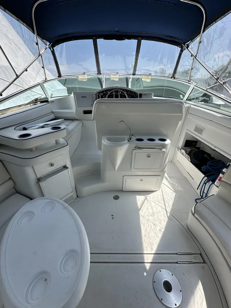 Slide: The Image of 1997 Chris-Craft 380 Continental B boat interior with white seating and blue canopy. - 6