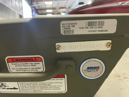Slide: The Image of 2024 Tracker Grizzly 1236 Jon boat transom with warning labels and certification stickers. - 5