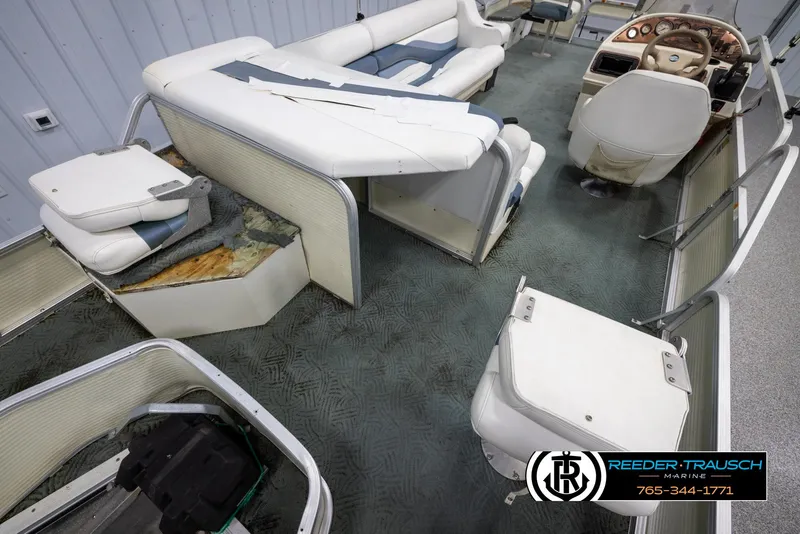 Slide: The Image of 2002 Suncruiser Trinidad 224 pontoon boat interior with damaged seating and worn flooring. - 22